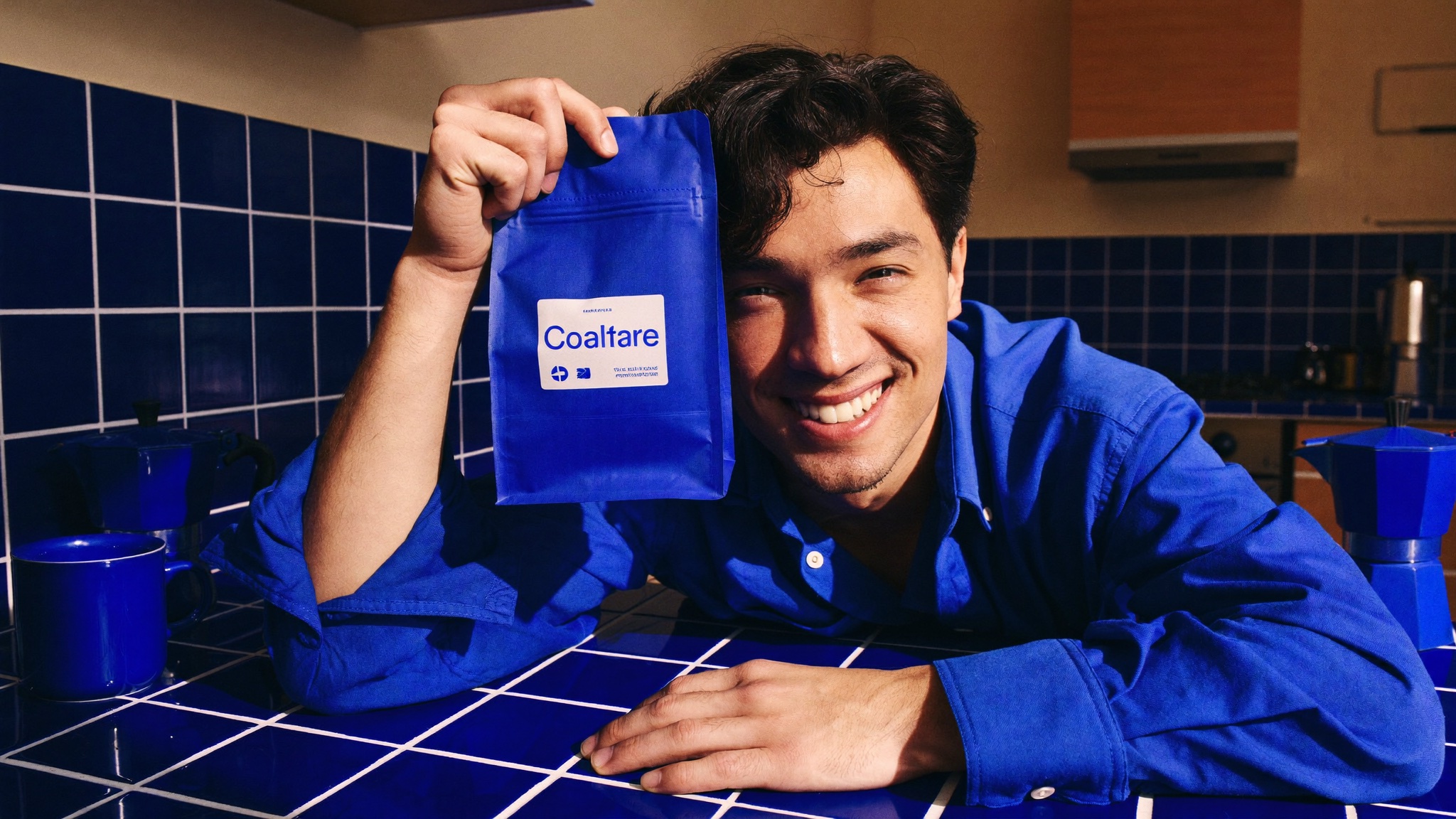 A creator holding a blue product pouch in a matching blue kitchen.